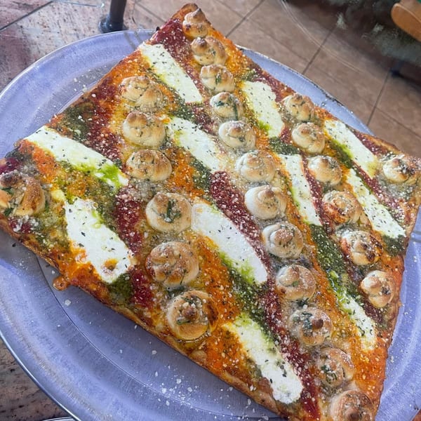 Square Luigi's Pizza with stripes of red sauce, pesto, mozzarella, and garlic knots.
