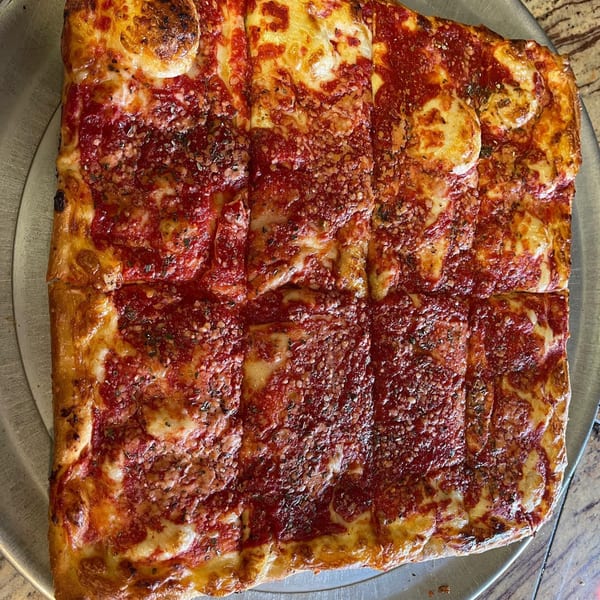 A square-cut Luigi's Pizza with thick crust, rich red sauce, melted cheese, and herbs.