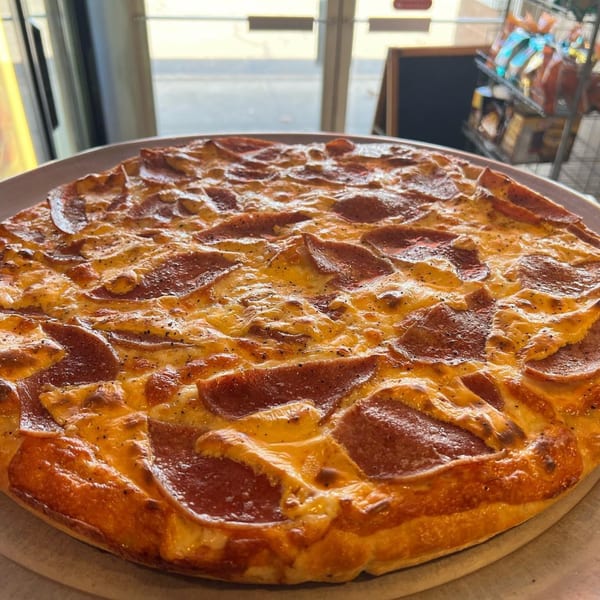 A freshly baked pepperoni pizza from Luigi's Pizza, with melted cheese and a golden crust.