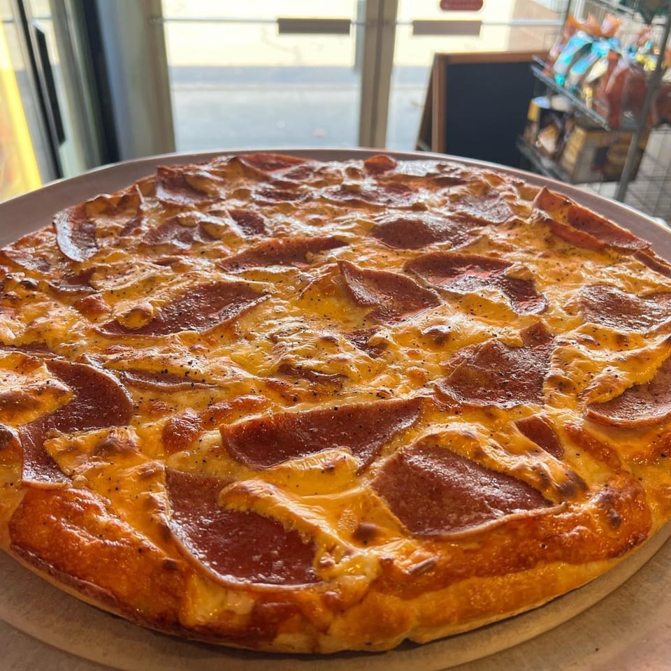 A freshly baked pepperoni pizza from Luigi's Pizza, with melted cheese and a golden crust.