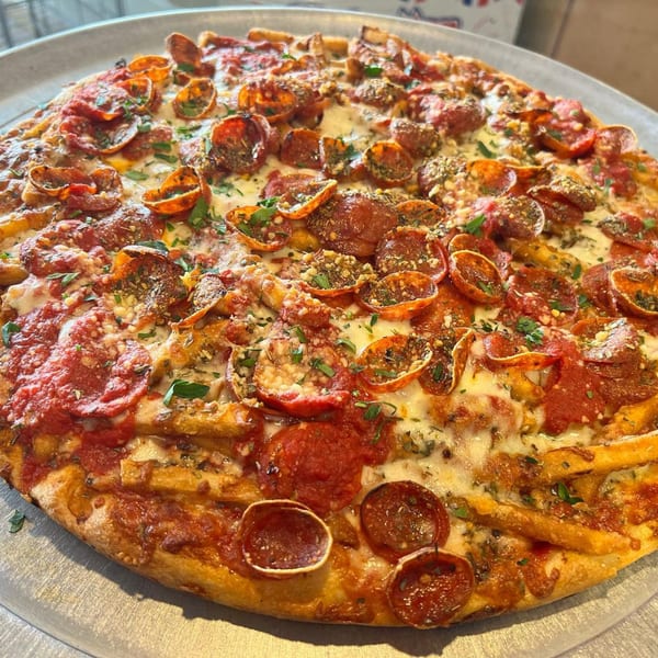 Luigi's Pizza with pepperoni, cheese, sauce, and french fries on a metal tray.