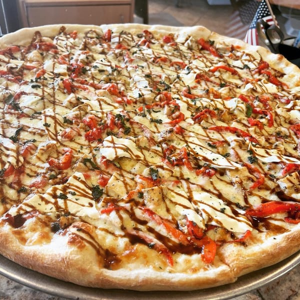 Luigi's Pizza with white sauce, chicken, red peppers, and a balsamic glaze drizzle.